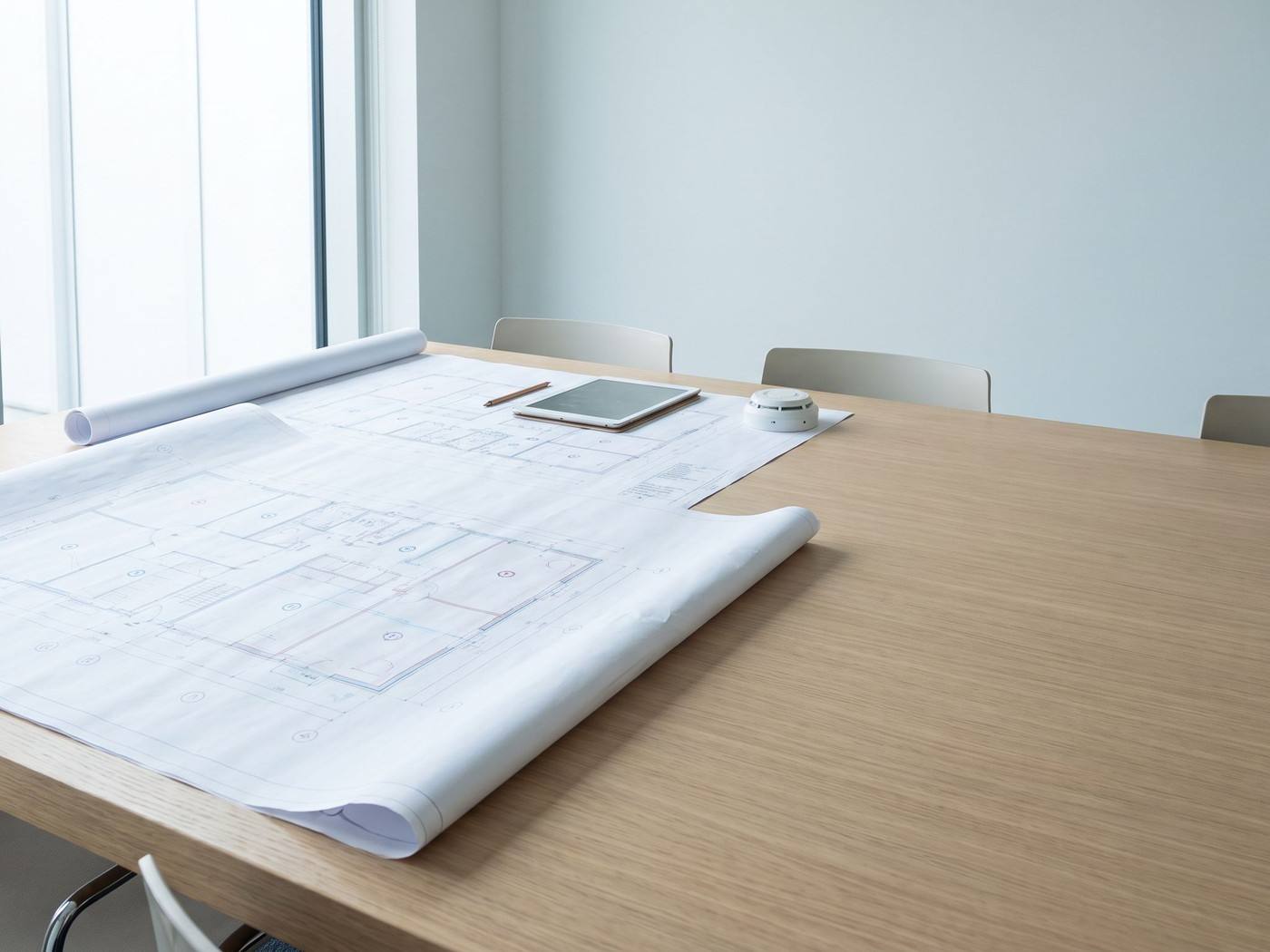 Deux professionnels examinent des plans de construction avec les compartiments coupe-feu sur une table de réunion