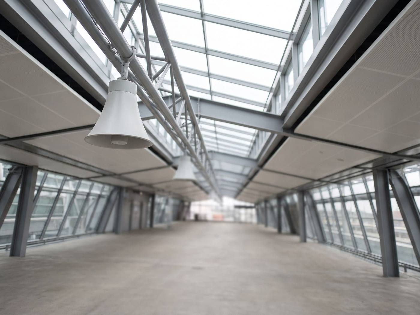 Un inspecteur effectue une mesure acoustique sous les haut-parleurs du hall d'une gare